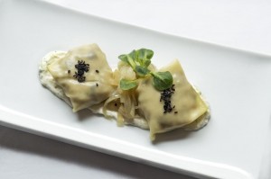 Raviolis de setas y gambas, cebolla confitada y crema de queso